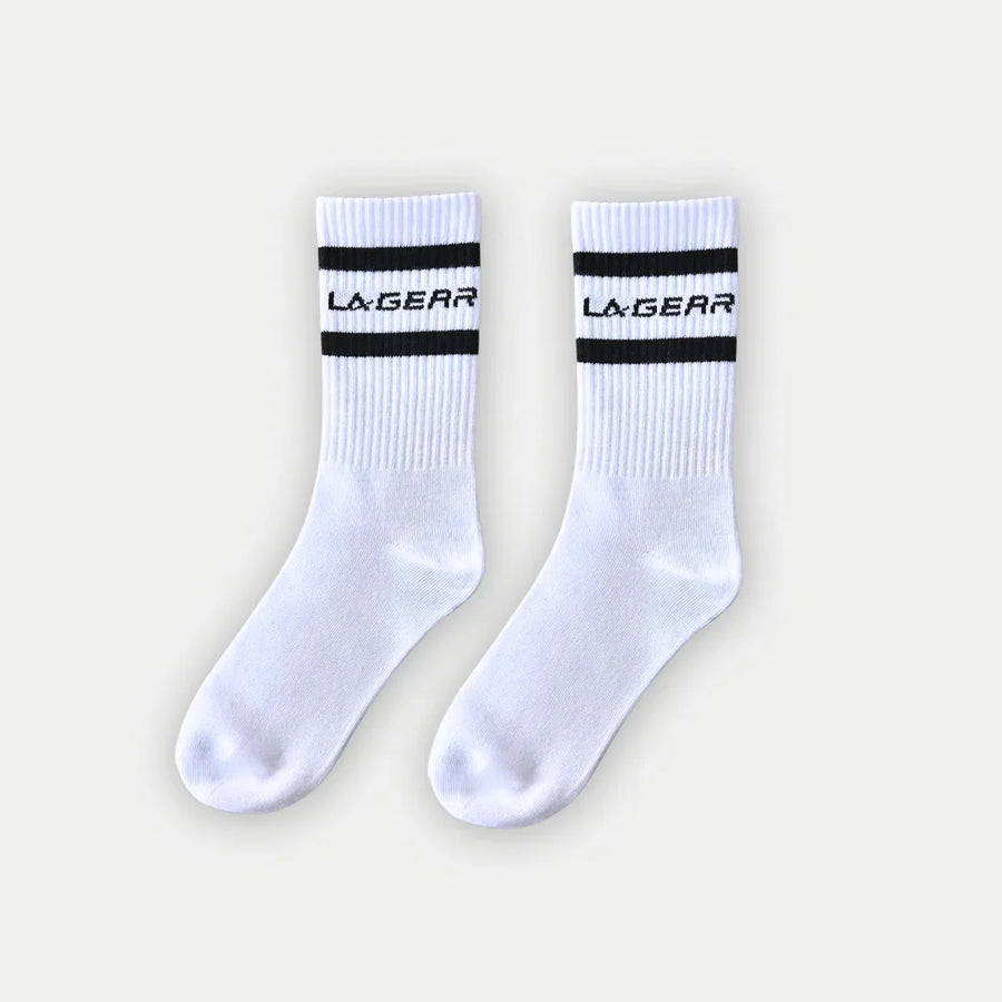 White socks with black stripes and 'La Gear' branding on a light gray background