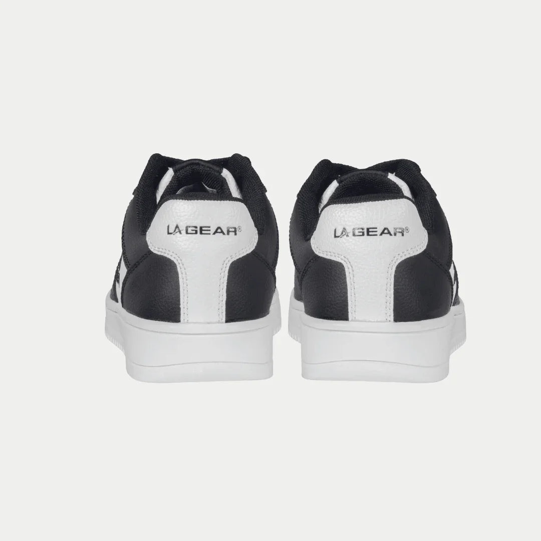 Black and white lowtop sneakers with 'La Gear' branding on a light gray background