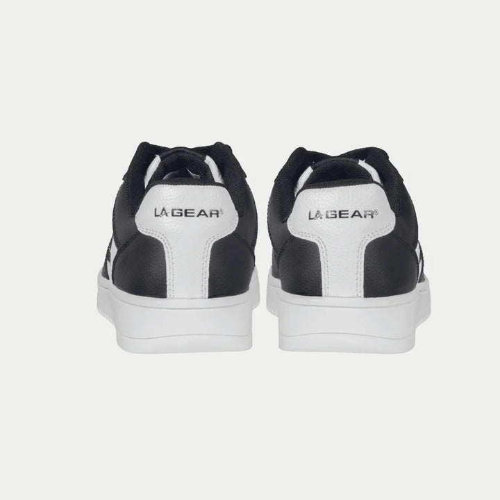 Black and white lowtop sneakers with 'La Gear' branding on a light gray background