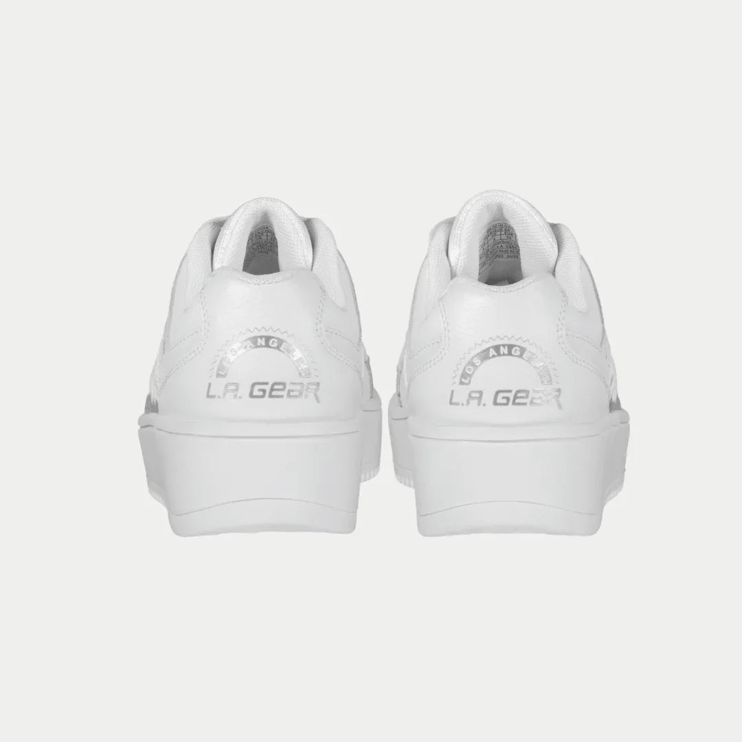 White lowtop sneakers with 'LA Gear' branding on a light gray background