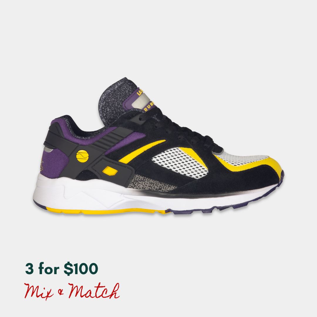 Black, purple, and yellow LA Gear sneaker with a rechargeable light-up tongue on a light gray background