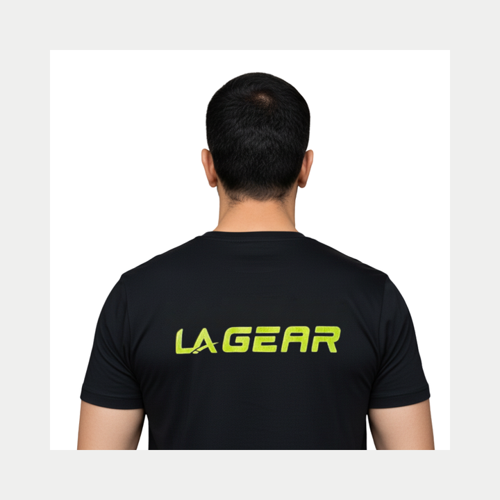Person wearing a black t-shirt with 'LA Gear' logo on the back against a white background