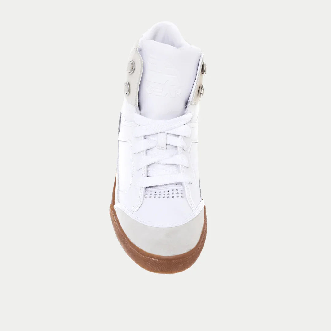 White sneaker with a brown sole on a light gray background