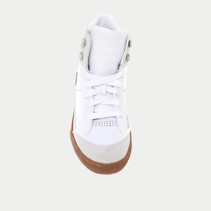 White sneaker with a brown sole on a light gray background