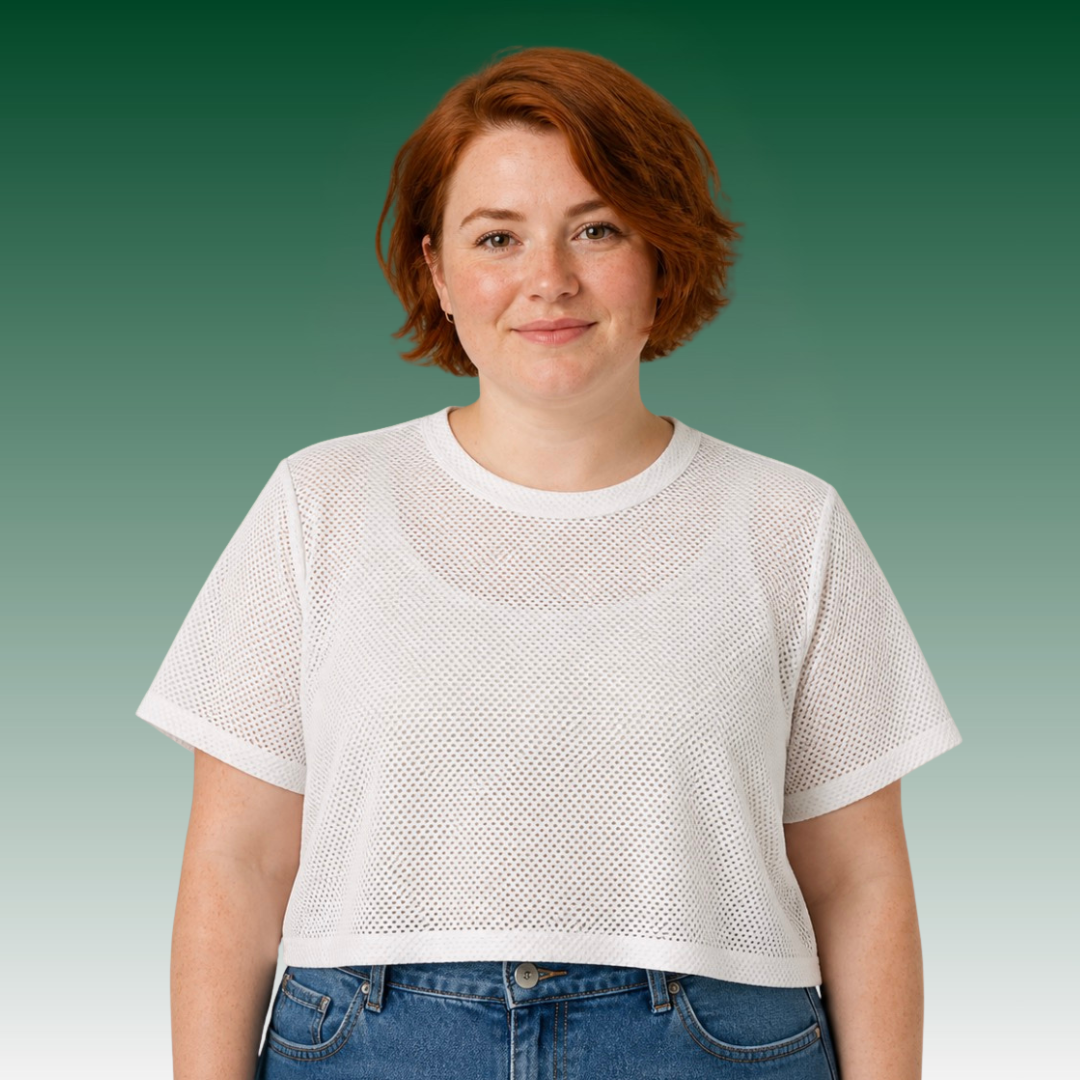 A women wearing a white mesh tee and high-waisted jeans.