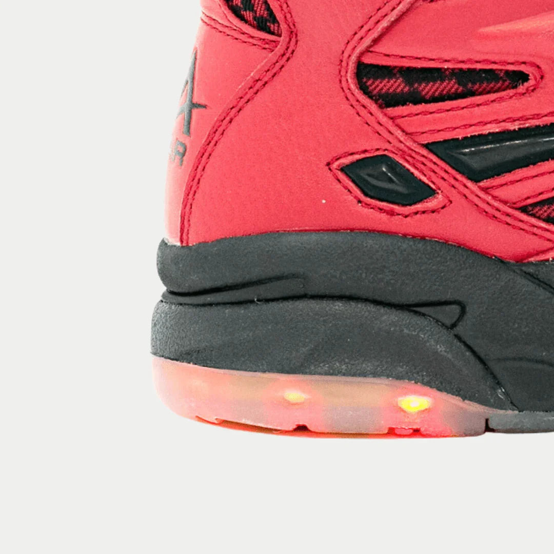 Close-up of a red x black sneaker with light-up sole on a light gray background