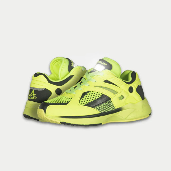Bright neon yellow lowtop shoes with black accents on a light gray background