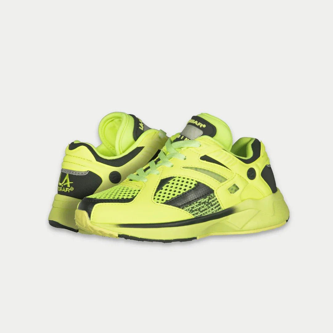 Bright neon yellow lowtop shoes with black accents on a light gray background