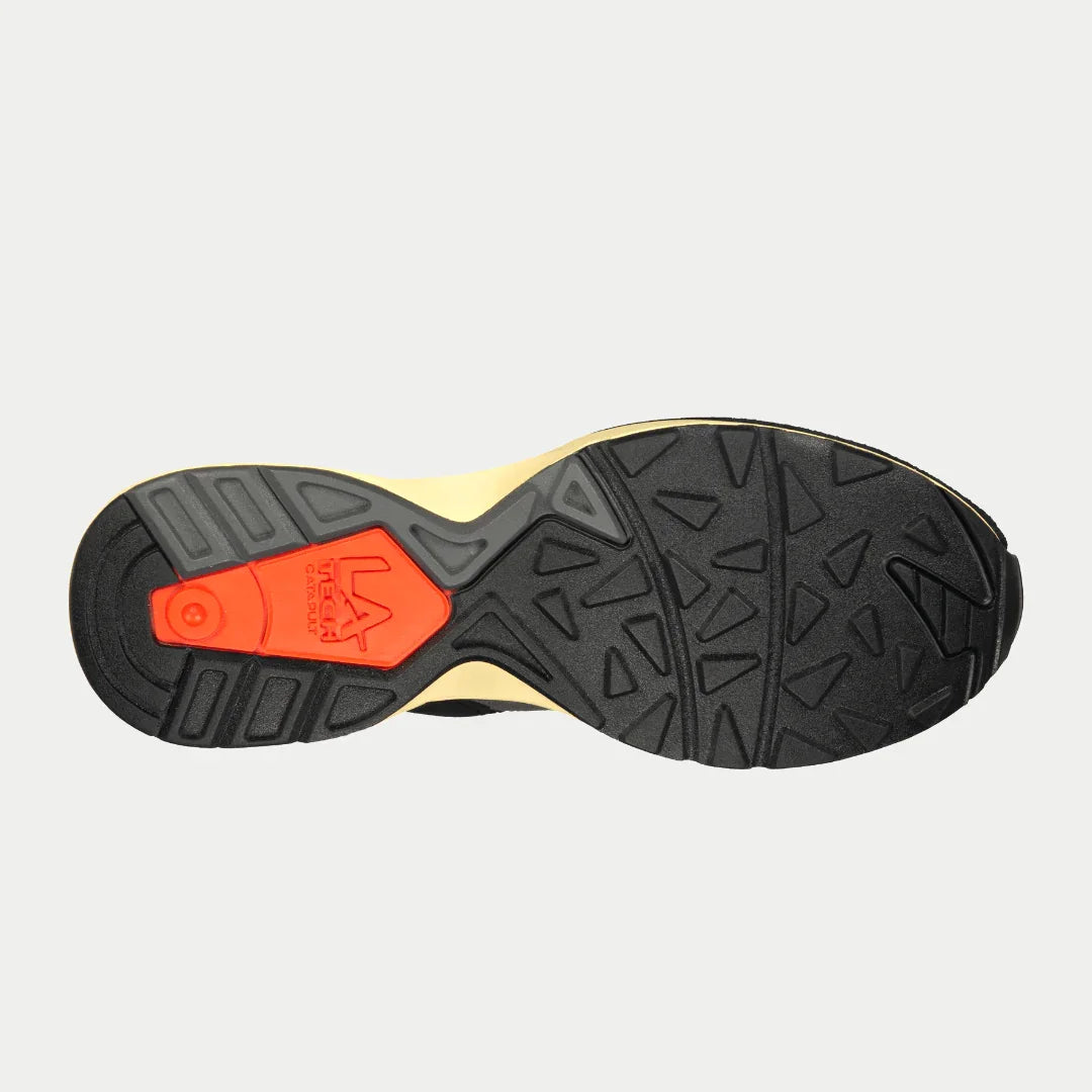 Close-up of a shoe sole with a orange logo on a light gray background