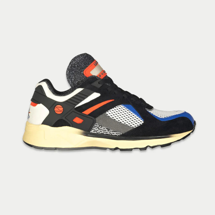 Multicolored sneaker with black, white, orange, and blue accents on a light gray background