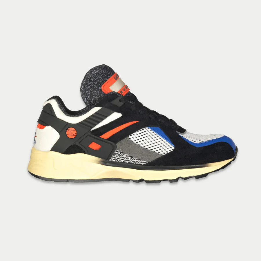 Multicolored sneaker with black, white, orange, and blue accents on a light gray background