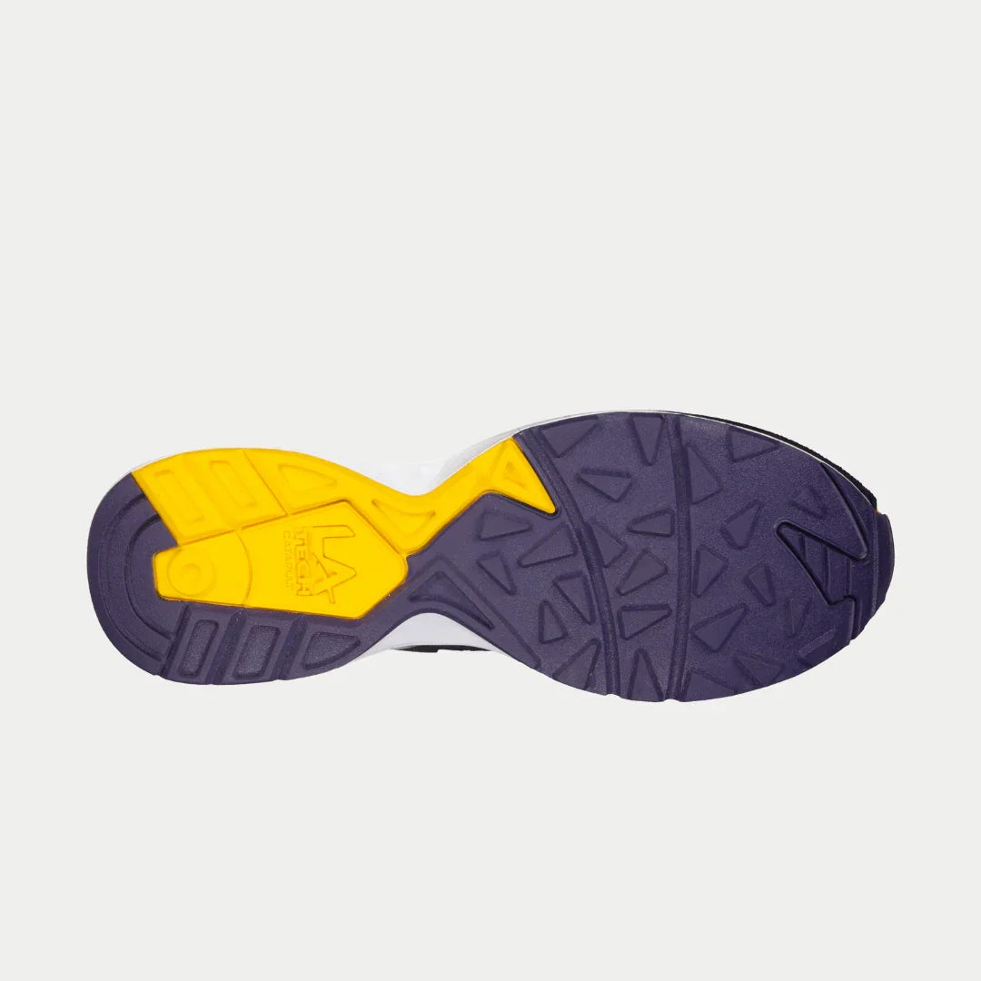 Sole of a shoe with purple outsole and yellow inner sole on a light gray background
