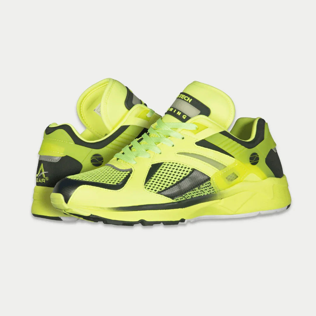 Neon yellow x black  shoes with black accents on a light gray background
