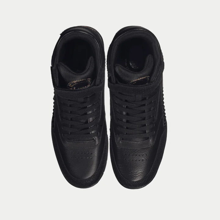 Pair of black hightop sneakers on a light gray background