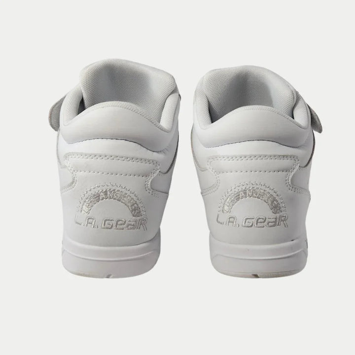 White athletic shoes with 'LA-GEAR' branding on a light gray background